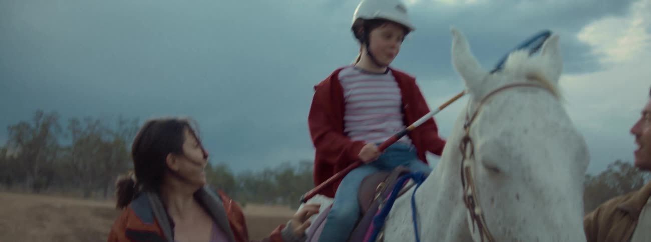 Mother and father walk beside a horse their daughter is riding