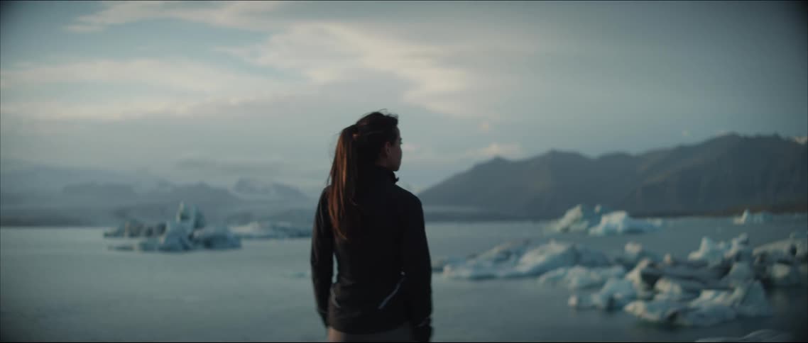 A woman looks at the icebergs in the water
