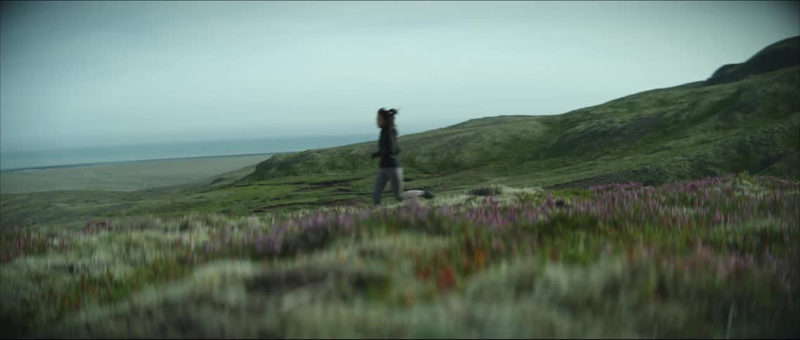 A woman running through a field of flowers