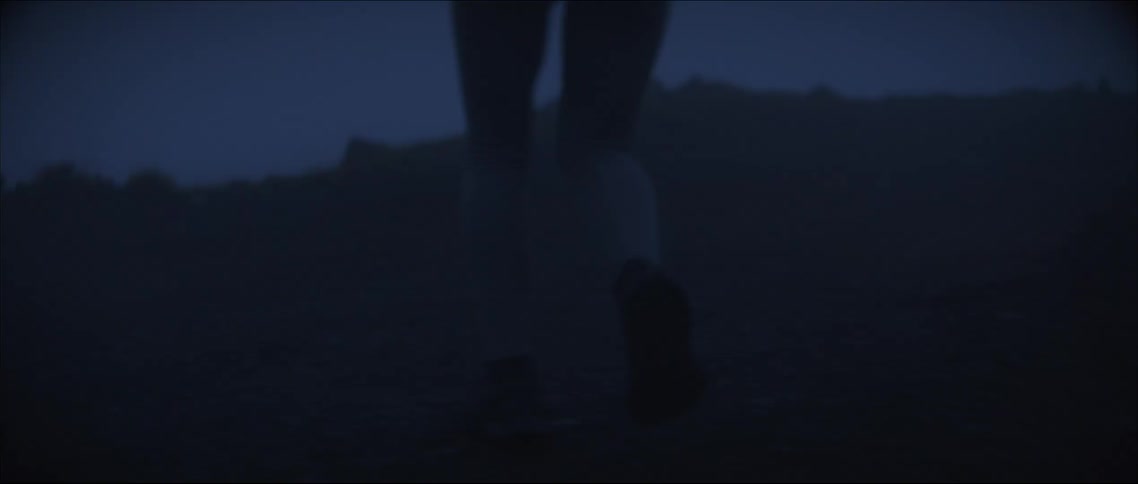 Woman runs across terrain at night using a headlamp