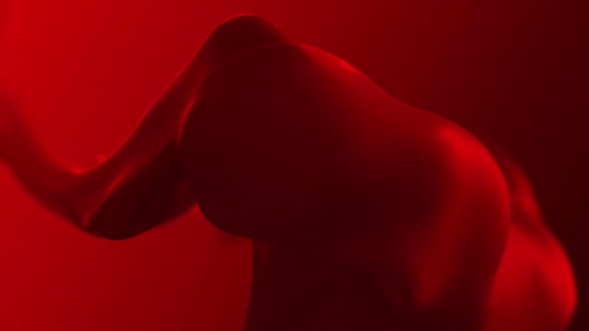 Red glowing fabric flows and shifts changing shape in a shadow