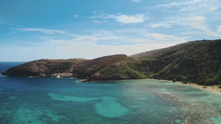 Aerial view of people on a tropical beach with beautiful clear blue waters and reefs