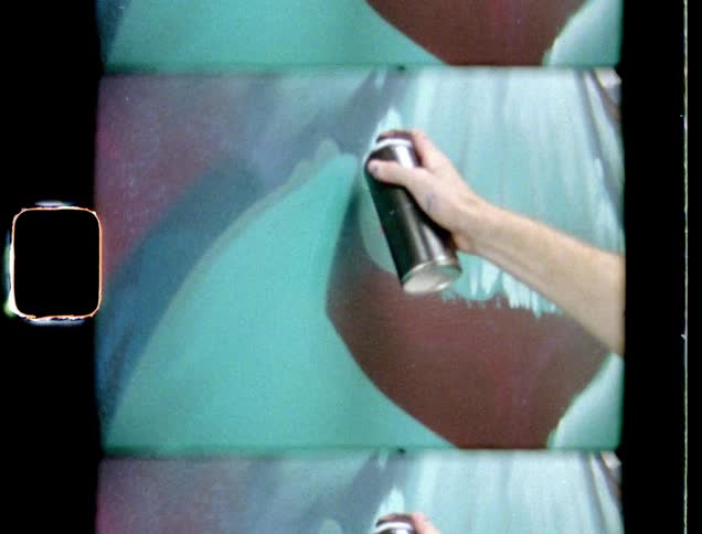 A person is holding a can of spray paint in their hand and painting a picture on the wall of a building