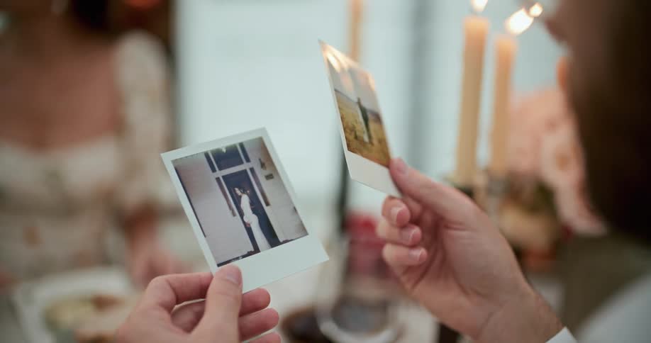 A man looks through polaroid photos of a couple while having dinner