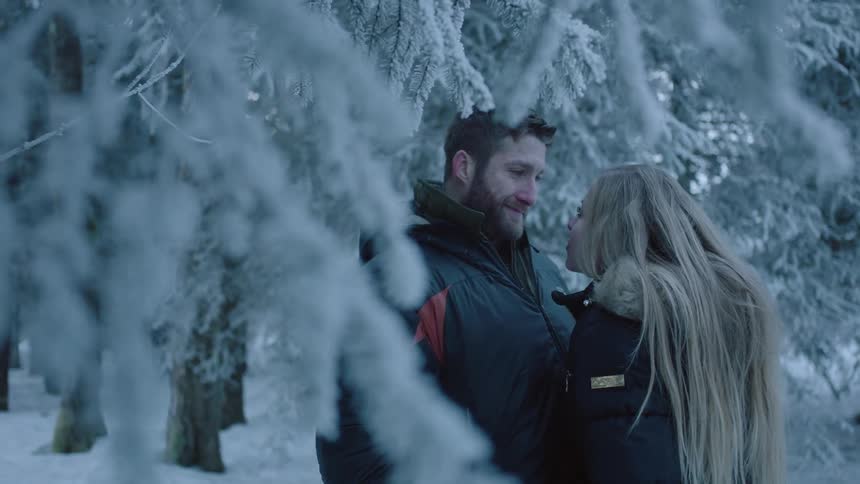 A woman looks up at a man standing in front of her
