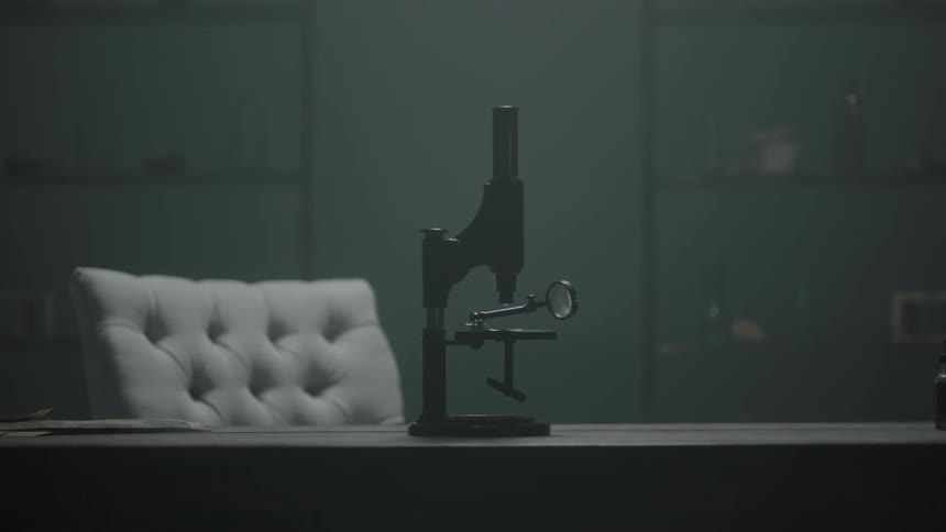 An old-fashioned microscope sits on a desk