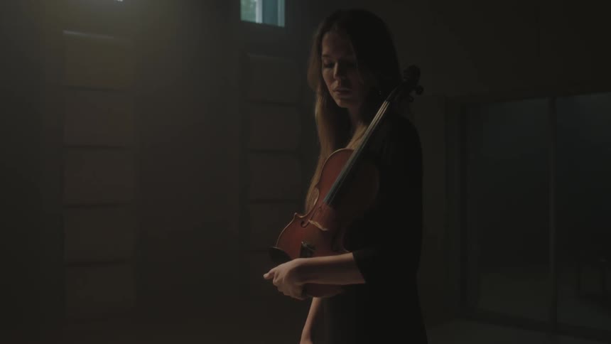 A woman holds a violin