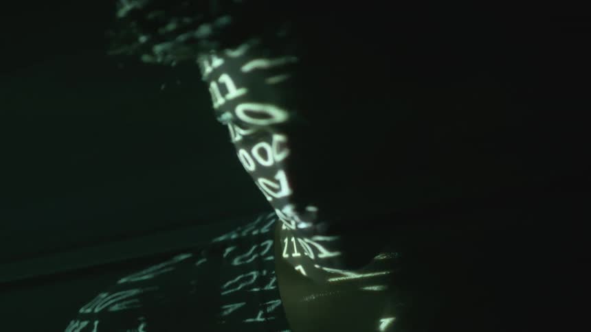 Numbers are projected onto a man's face