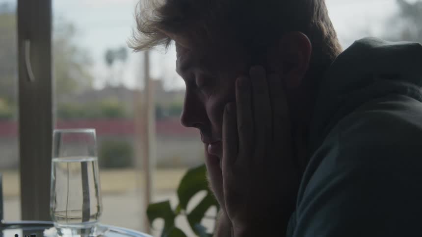 A man talking to someone at home at a table
