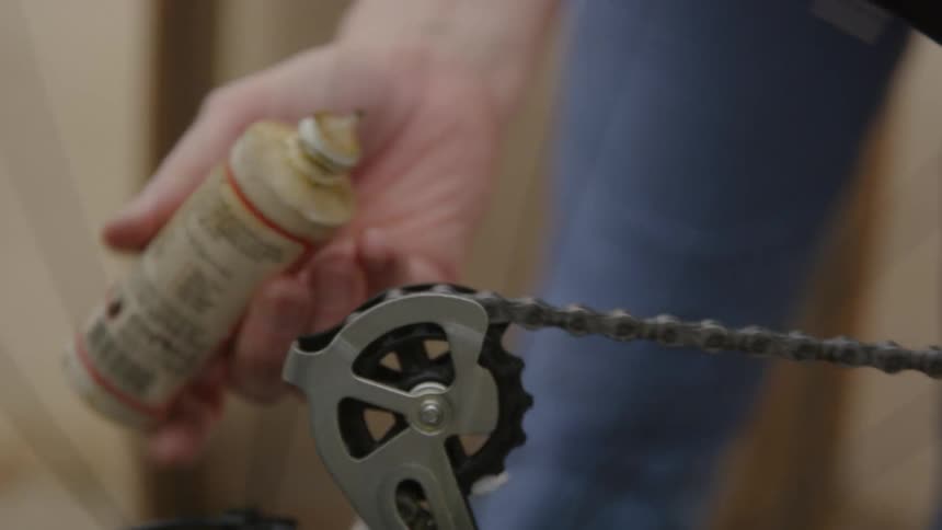 A man oils the chain on his bicycle