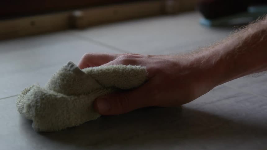 A man is cleaning a table with a towel