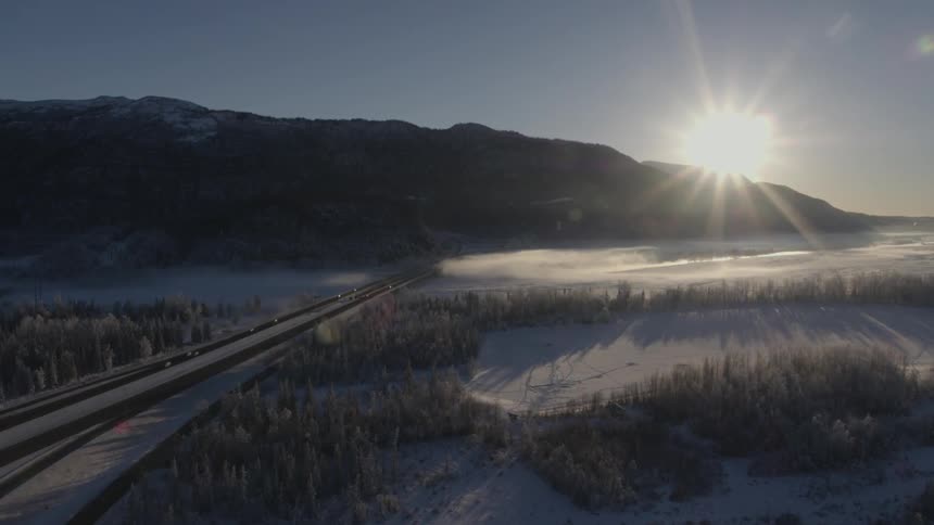 The sun rises over a snow covered mountain