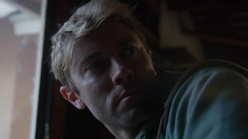 A man is standing in a room next to a window