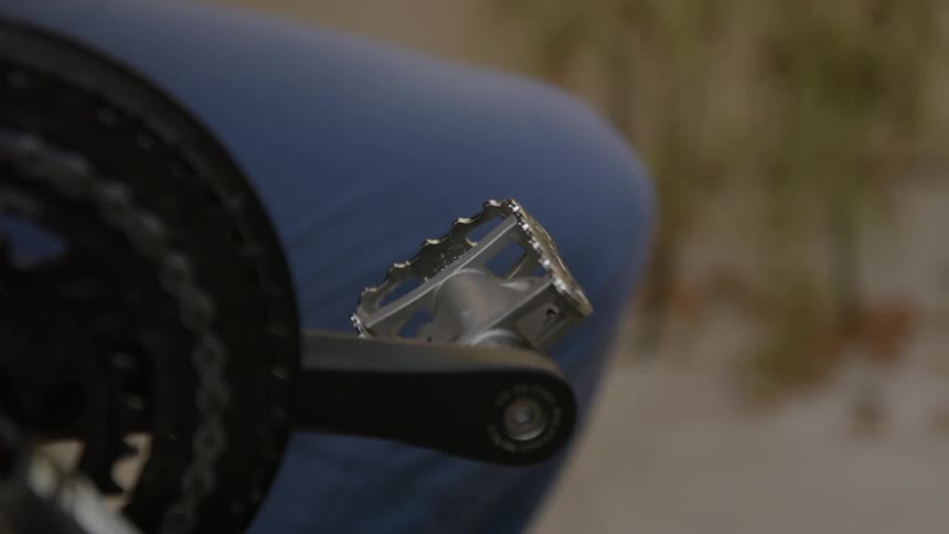 Man touching bicycle pedal lets it go