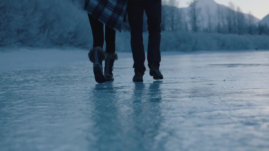 Two people walk on ice