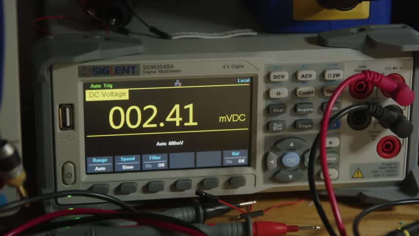 Numbers are displayed on the screen of a voltmeter as it reads a voltage