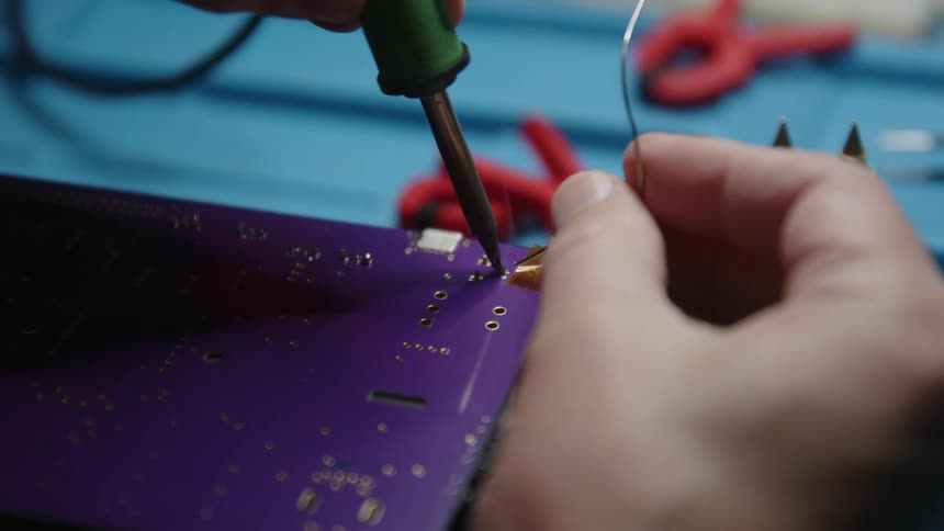 A man is soldering a machine
