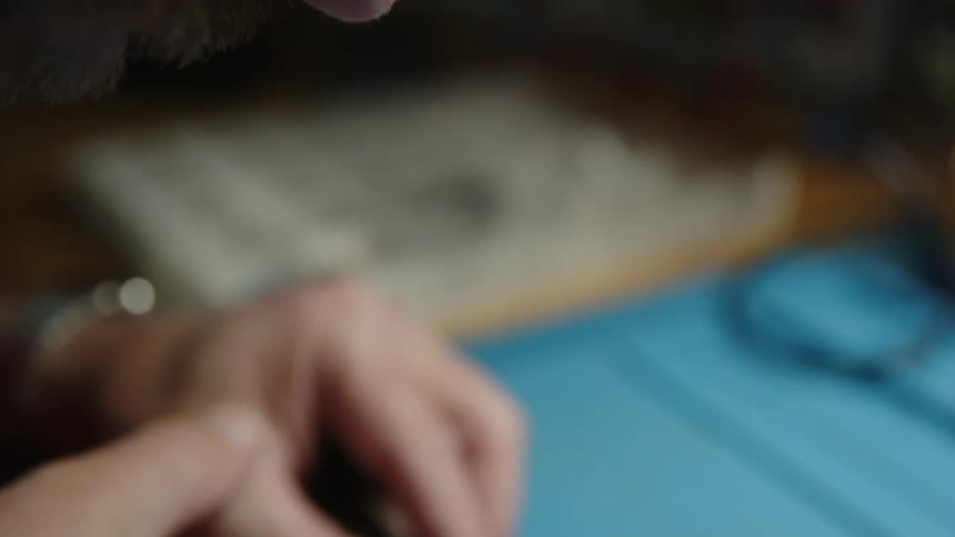 A man is carefully placing small components on a circuit board