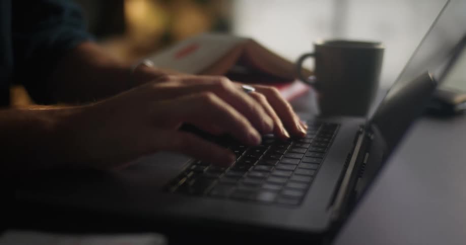Person sitting at deskhome office typing on laptop keyboard