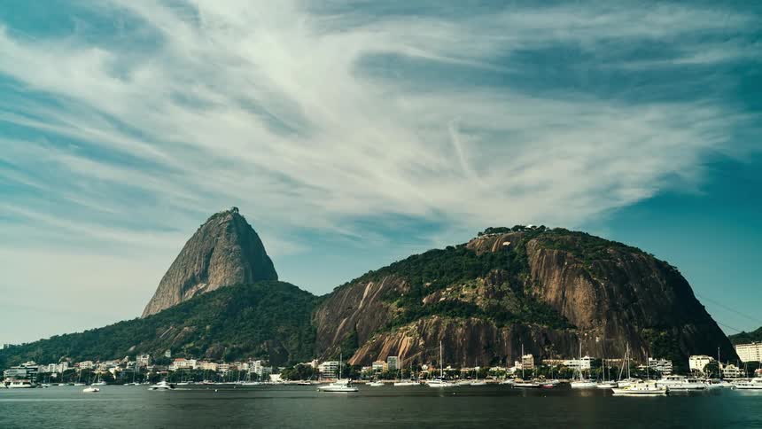 Wide view of sugarloaf mountain in rio de janeiro from the water with lots of boats