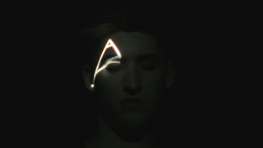 Lights of images flash on a man's face