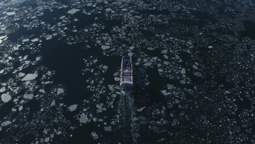 A boat is sailing in the icy water