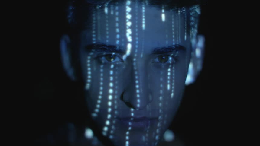 A projection is lighting on a man's face