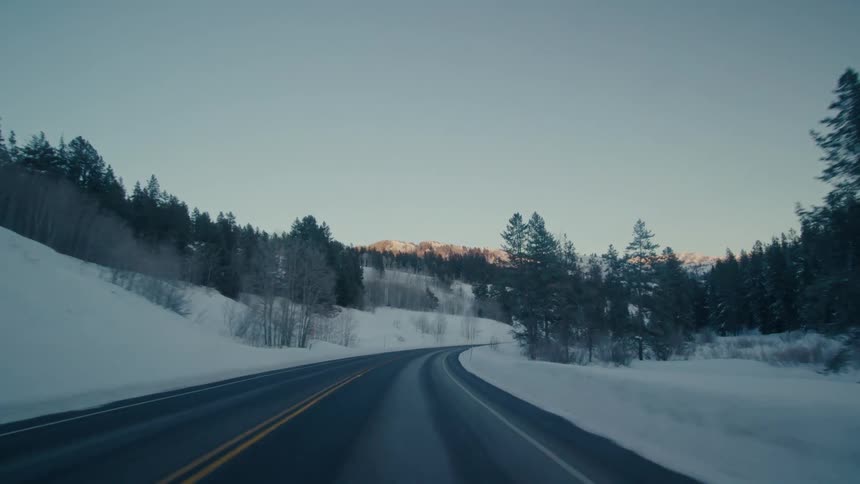 A view of snow covered rural highway is displayed