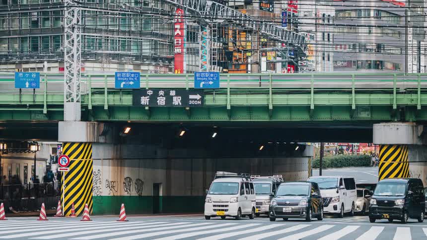 Traffic passes through a busy intersection under a bridge downtown
