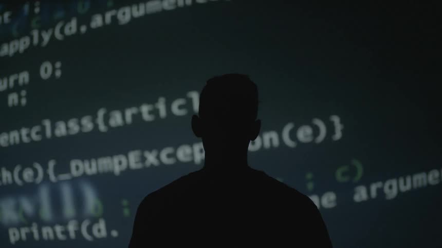 A man watches a projection on the wall