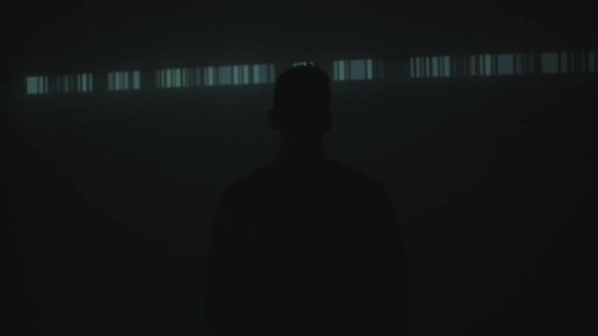 A man stands in front of a large projection display