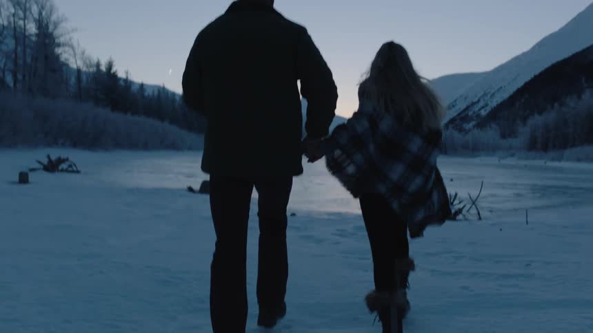 Two people run together over the ice and snow