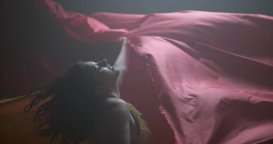 A woman waves a long sheet around