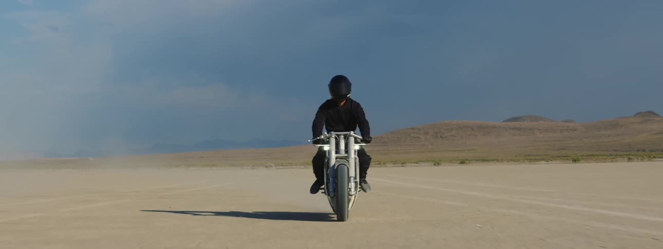 A man rides his motorcycle in the desert