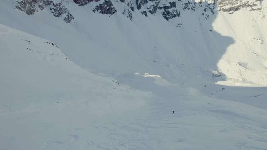 Aerial view of person snowboarding down mountain
