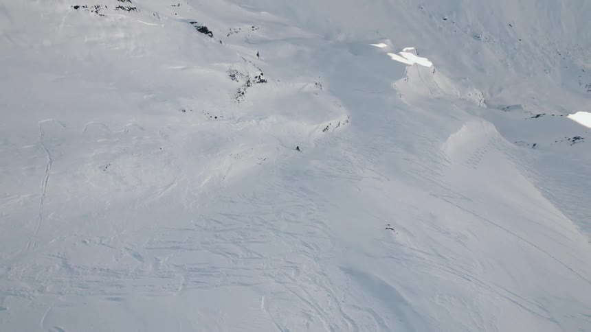 A person is skiing down a mountainous landscape