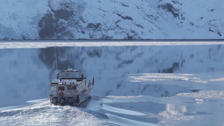 A boat is sailing in the ice filled water
