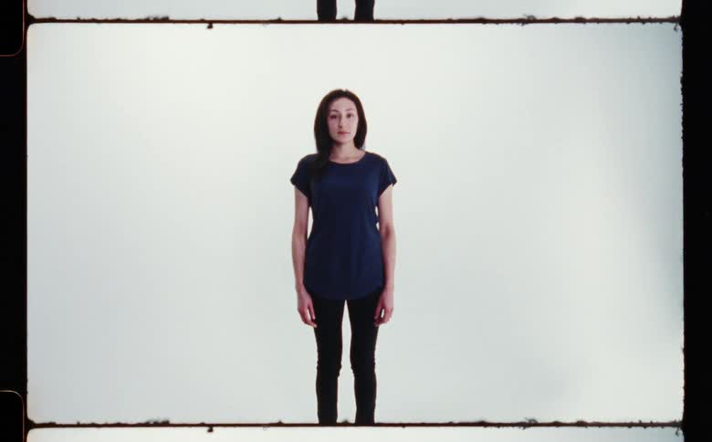 A woman standing for a portrait in front of a white background