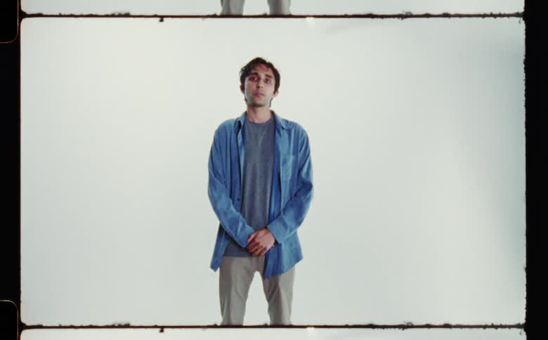 A man is standing near a wall for a portrait