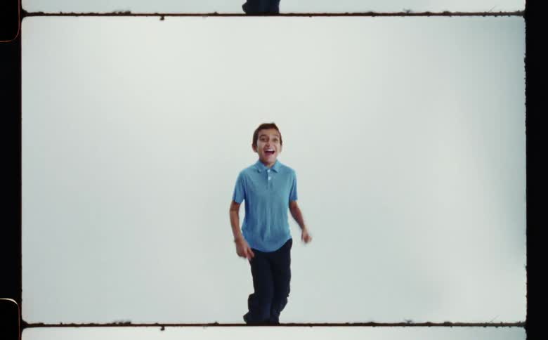 A young boy is smiling while jumping up and down