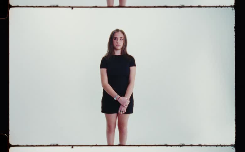 Woman with brown hair and black dress poses for the camera in the studio