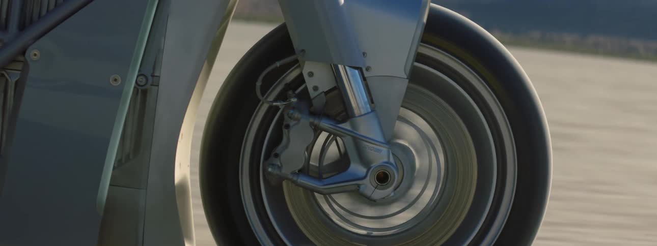 A person is driving a motorcycle through a desert area