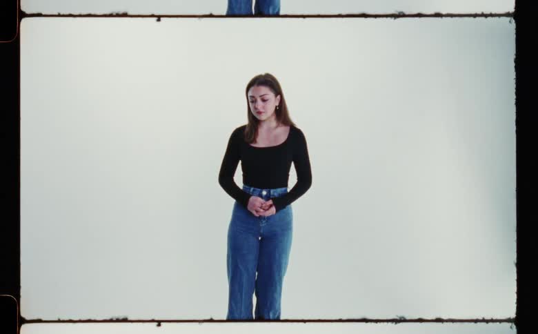 A female is standing near a wall for the portrait