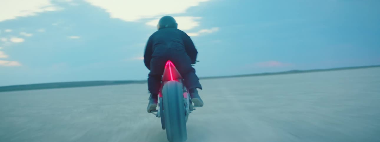 A person races through the desert on a motorcycle