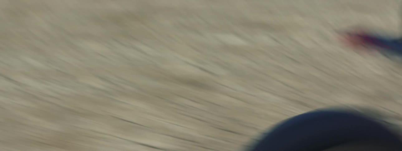A person is driving their motorcycle through the land