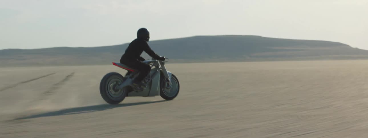A person is riding their motorcycle through a deserted area