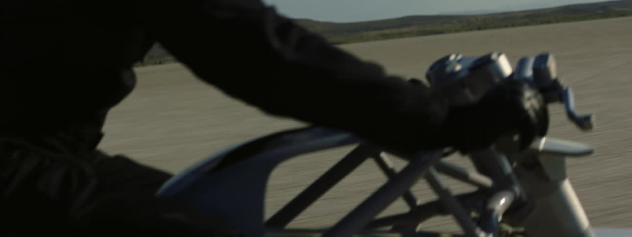 A person is riding their motorcycle through nature