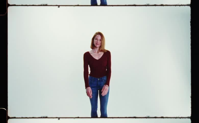 Redhaired woman walks forward to pose smiling