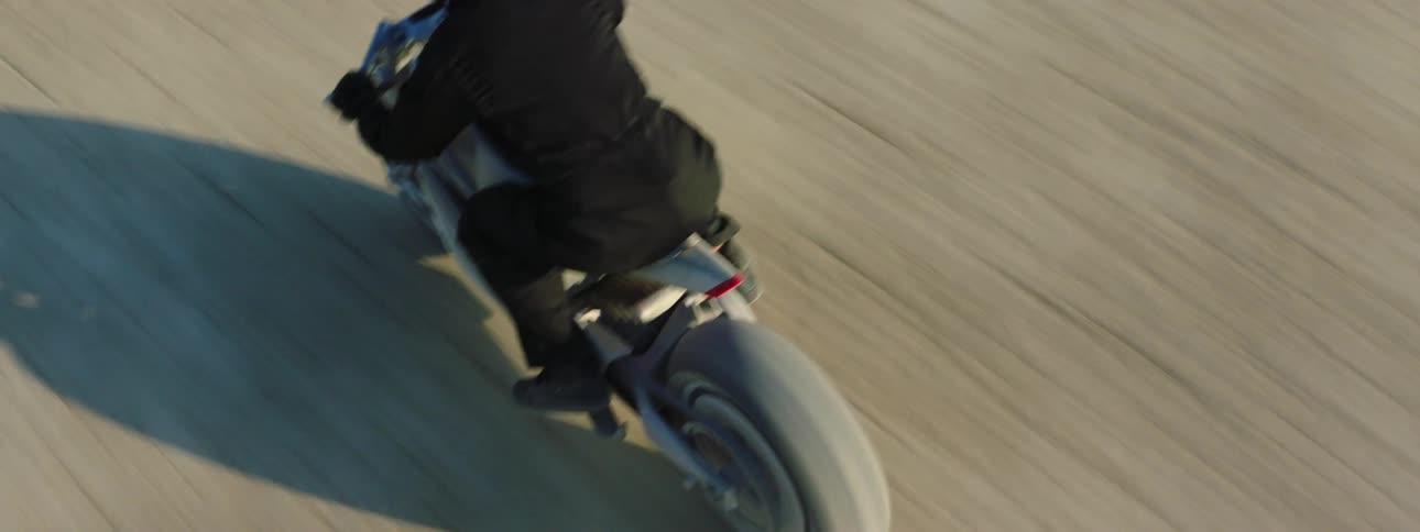 A person is riding through the desert on a motorcycle