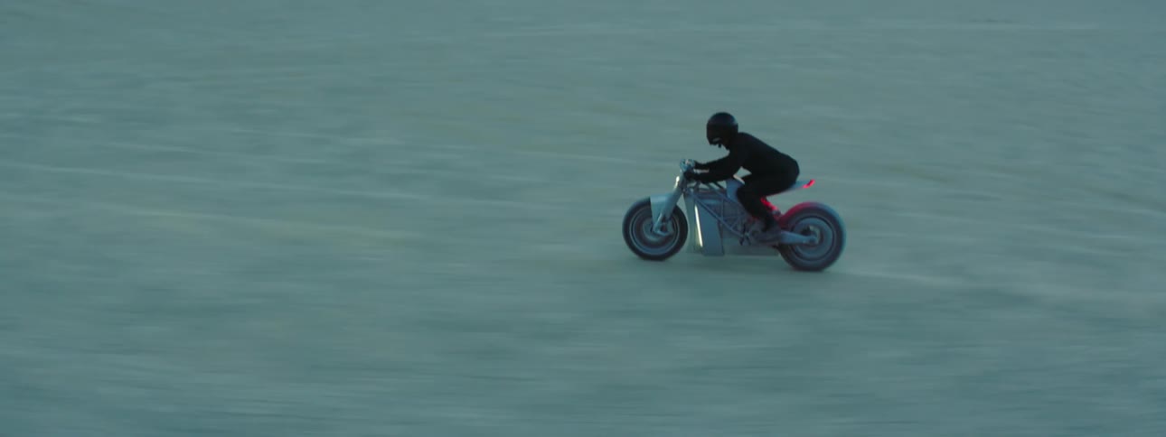A person is riding through the desert on a motorcycle